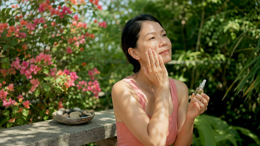 Woman applying Japanese skincare essence in bathroom