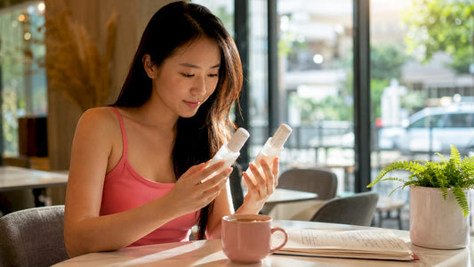 Woman comparing brightening and whitening skincare bottles