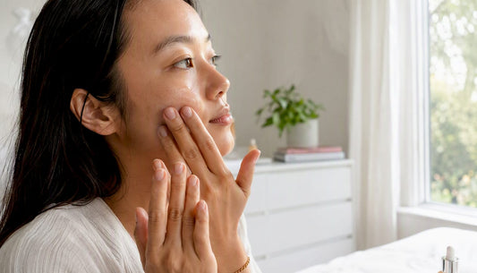Hands applying skincare serum to face