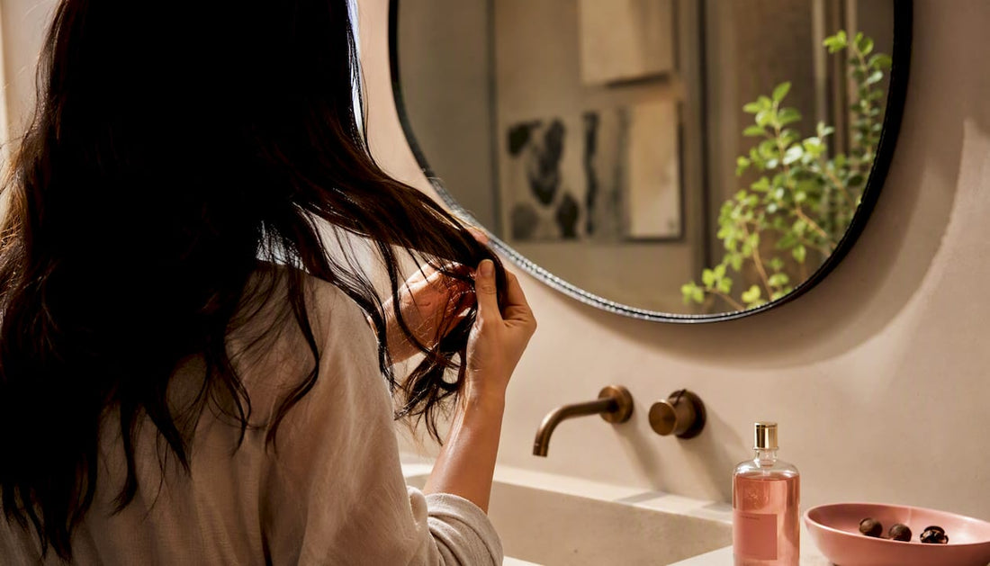 Hands applying camellia oil to hair ends