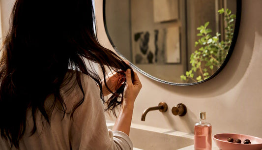 Hands applying camellia oil to hair ends