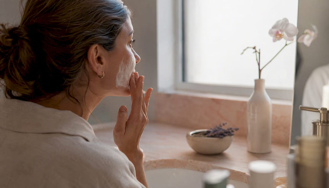 Hands applying skincare serum to face