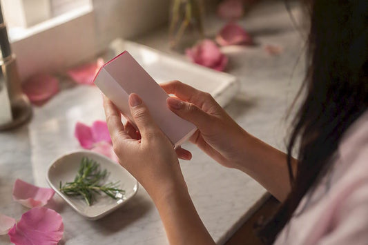 Hands examining skincare package closely