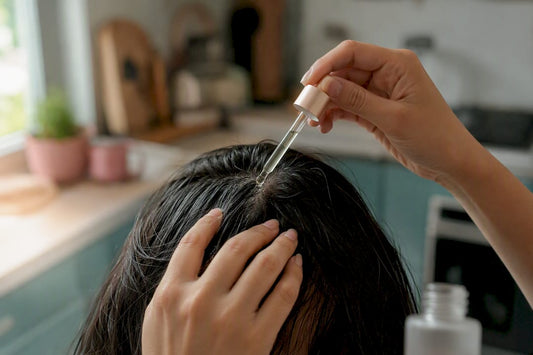 Hands applying tonic drops onto scalp