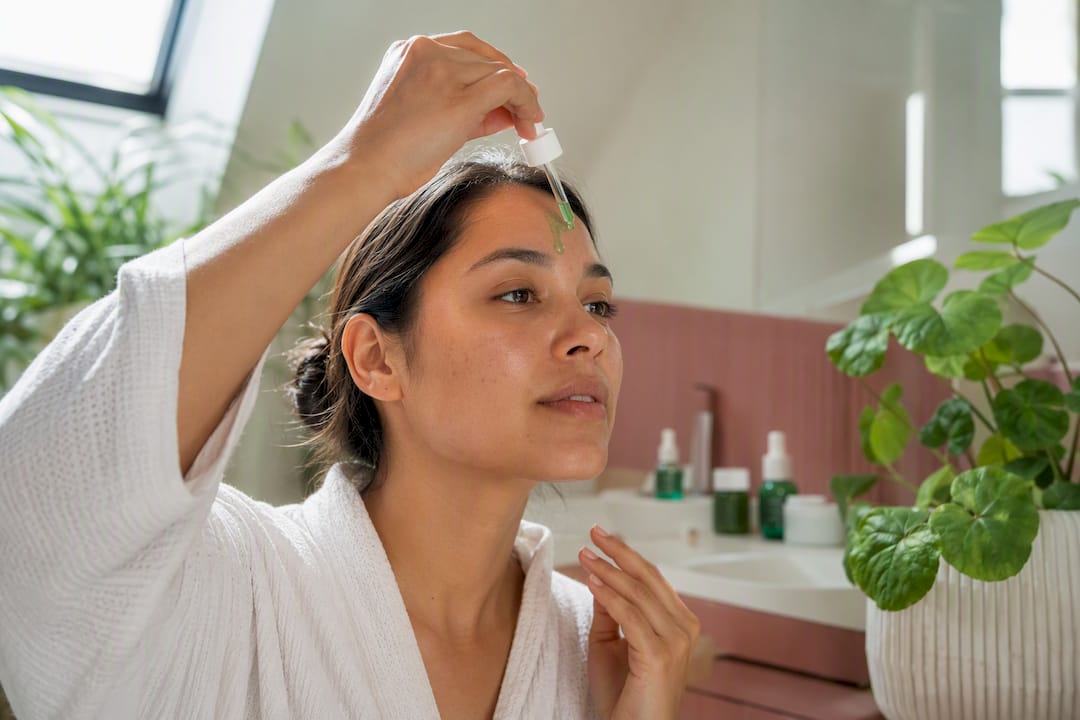 Hands applying centella asiatica serum on skin