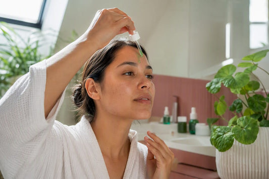 Hands applying centella asiatica serum on skin