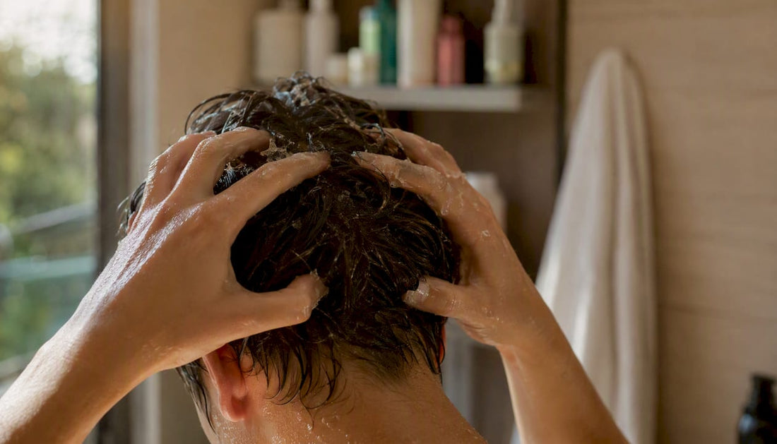 Hands applying Korean scalp exfoliant in bathroom